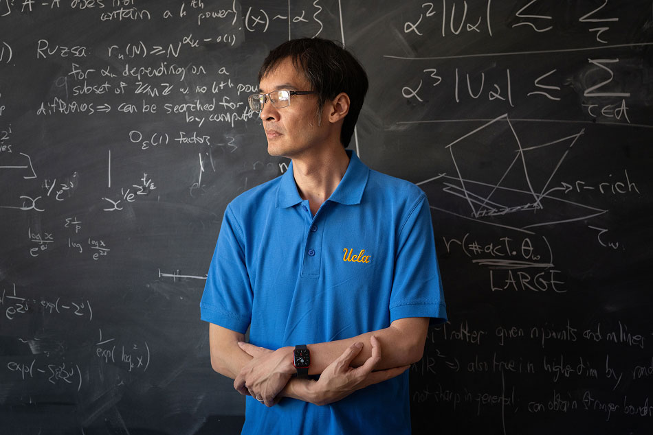 A young Professor Terence Tao in front of a chalkboard